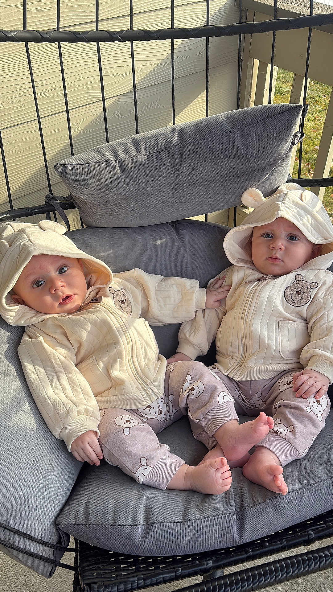 Adam And Yousef joined the competition — help win amazing prizes! baby, toddler, child, matching_outfits, hoodie, bear_ears, bear_print, pants, bare_feet, cushion, swing_chair, outdoor, porch, person, cute, infant, seated, clothing, face, expression