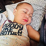 Takeshi joined the competition — help win amazing prizes! baby, sleeping, child, pillow, blanket, pattern, shirt, text, face, arm, indoor, rest, cozy, peaceful, closeup, infant, young_child, portrait, soft_lighting, comfort