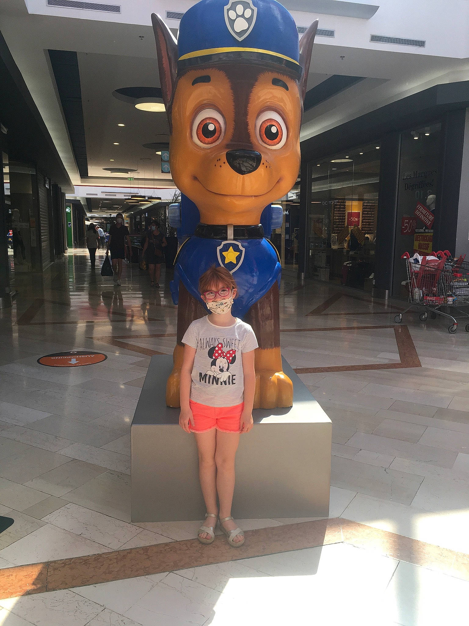 Amélia participe au concours pour gagner de l'argent avec cette photo : art, building, fictional_character, flooring, fun, human_leg, leisure, logo, mascot, metal, person, recreation, retail, room, shorts, statue, t_shirt, tourism, tourist_attraction, travel