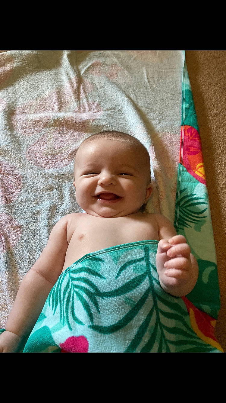 Gabe is registered to the contest to win money with this photo: baby, baby_toddler_clothing, child, comfort, eye, fun, gesture, grass, happy, iris, linens, magenta, pattern, person, pink, skin, smile, t_shirt, textile, thumb