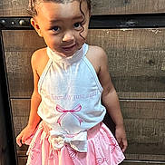 Sunnie is registered to the contest to win money with this photo: child, girl, pigtails, pink_skirt, white_sandals, smiling, standing, wooden_floor, wooden_background, cute, fashion, portrait, happy, indoor, person, clothing, footwear, hair_accessories, playful, toddler