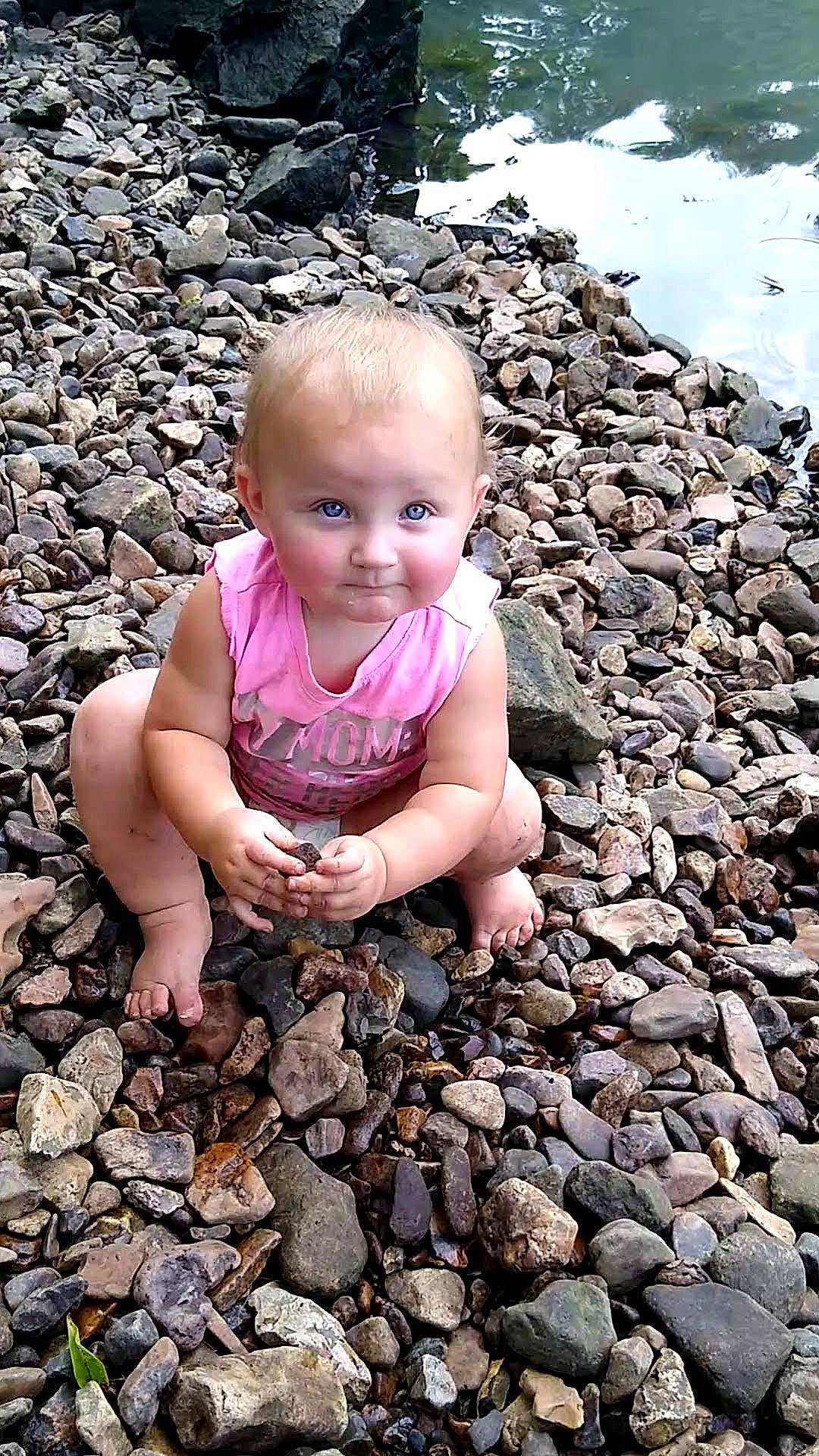 Juniper is registered to the contest to win money with this photo: baby, baby_toddler_clothing, cheek, eye, face, facial_expression, flash_photography, fun, grass, happy, head, human_body, leisure, mouth, people_in_nature, person, smile, standing, toddler, water