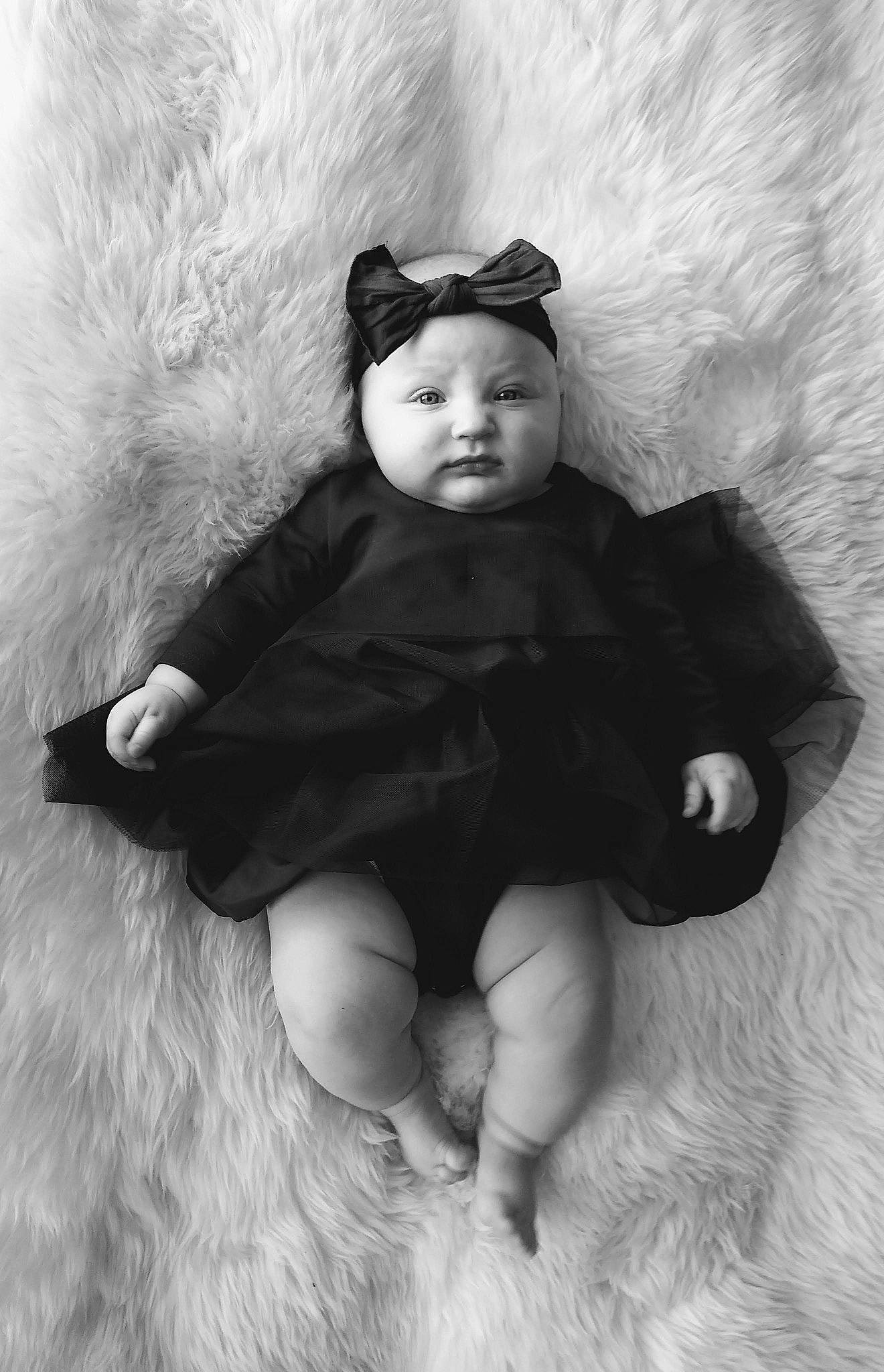 Juniper is registered to the contest to win money with this photo: arm, baby, baby_toddler_clothing, black_and_white, child, comfort, costume_hat, flash_photography, fur, gesture, happy, headwear, human_body, monochrome, monochrome_photography, person, skin, sleeve, stock_photography, style
