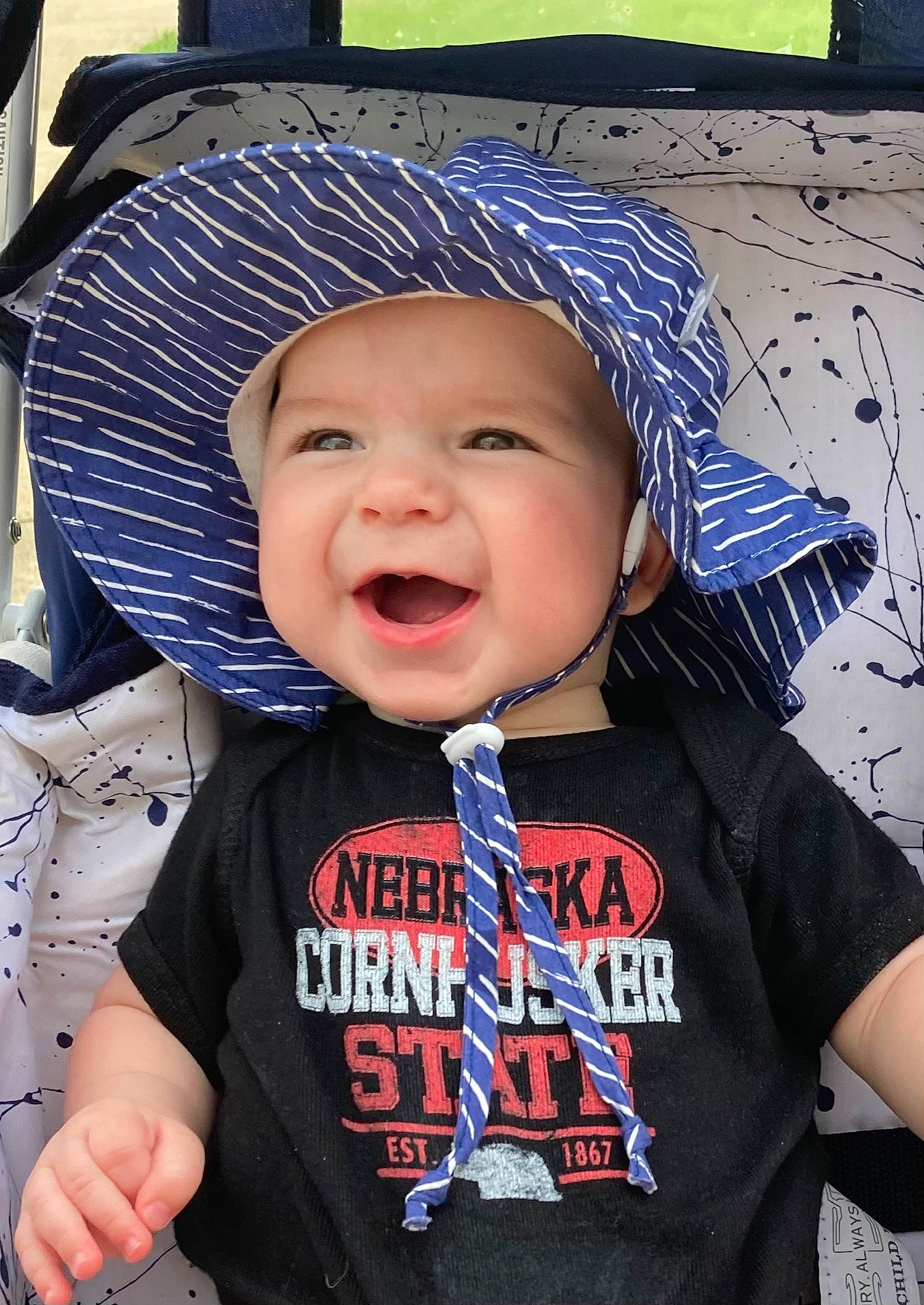 Judah is registered to the contest to win money with this photo: baby, baby_laughing, baby_toddler_clothing, blue, cap, clothing, cool, costume_hat, eye, face, gesture, happy, hat, headgear, headwear, helmet, outerwear, person, sleeve, smile