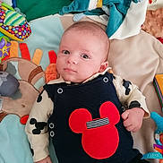 Jules a rejoint le concours — aidez-le/la à gagner de superbes lots ! baby, infant, child, playmat, toy, colorful, clothing, red, blue, face, hand, cute, indoor, lying_down, pattern, fabric, soft, collar, buttons, expression