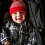 Jules a rejoint le concours — aidez-le/la à gagner de superbes lots ! baby, child, smile, hat, red_hat, striped_hat, plaid_shirt, clothing, happy, face, infant, jacket, black_jacket, portrait, cute, young_child, indoors, person, baby_clothes, closeup