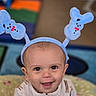 baby, background, blue, bunny_ears, child, clothing, colorful, comfort, cushion, cute, eyes, face, happy, headband, indoor, infant, pattern, portrait, smile, young