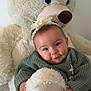 adorable, baby, child, comfort, cuddly, cute, flower_headband, green_sweater, happy, headband, hugging, indoor, infant, plush_toy, portrait, smiling, soft_texture, teddy_bear, warm, young_child