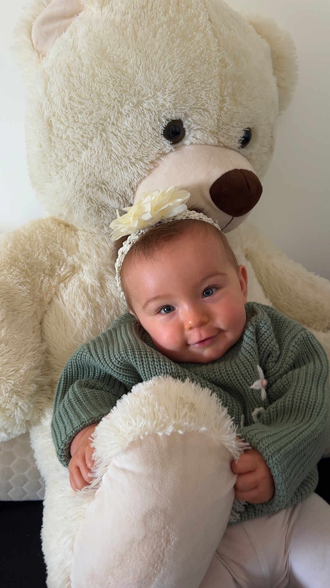 Soline Soyez participe au concours pour gagner de l'argent avec cette photo : adorable, baby, child, comfort, cuddly, cute, flower_headband, green_sweater, happy, headband, hugging, indoor, infant, plush_toy, portrait, smiling, soft_texture, teddy_bear, warm, young_child