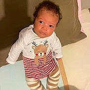 Martin a rejoint le concours — aidez-le/la à gagner de superbes lots ! baby, infant, child, cute, reindeer, striped_clothing, leggings, pillow, bed, blanket, lying_down, curious_expression, indoors, soft_toys, cozy, festive, red_and_white, brown, face, smiling