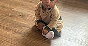 Maeast joined the competition — help win amazing prizes! toddler, child, floor, wooden_floor, sitting, indoor, crate, couch, clothing, socks, person, young_child, curious, home, natural_light, flooring, casual, looking, baby, portrait