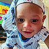 Maeast joined the competition — help win amazing prizes! baby, child, smiling, crawling, blue_clothing, patterned_clothing, indoor, television, cartoon, bed, blanket, face, person, cute, playful, headwear, young_child, home, expression, happy