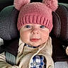 baby, child, pink_hat, pom_poms, knitwear, cardigan, blue_checkered, car_seat, infant, cute, portrait, face, eyes, clothing, warm, bundle, seatbelt, indoor, closeup, adorable