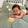 Emy a rejoint le concours — aidez-le/la à gagner de superbes lots ! baby, smiling, diaper, blanket, bed, head, face, happy, infant, toddler, indoors, furniture, pillow, toy, child, skin, person, cute, playful, comfort