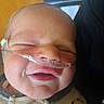 Lucas is registered to the contest to win money with this photo: baby, newborn, face, infant, nasal_cannula, medical, close_up, smile, sleeping, child, person, cute, skin, clothing, pattern, hospital, healthcare, young, portrait, head