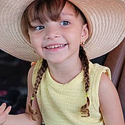 Agatha is registered to the contest to win money with this photo: child, girl, smiling, braids, hat, straw_hat, yellow_top, happy, portrait, cute, young, fashion, casual, outdoor, person, eyewear_absent, earrings, closeup, skin, hair