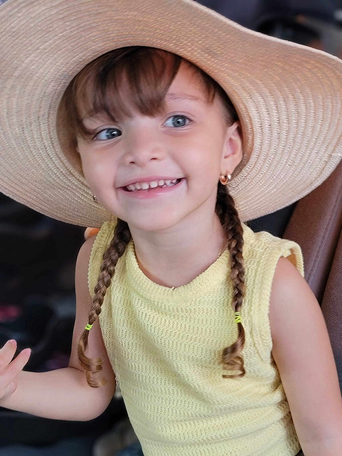 Agatha is registered to the contest to win money with this photo: child, girl, smiling, braids, hat, straw_hat, yellow_top, happy, portrait, cute, young, fashion, casual, outdoor, person, eyewear_absent, earrings, closeup, skin, hair