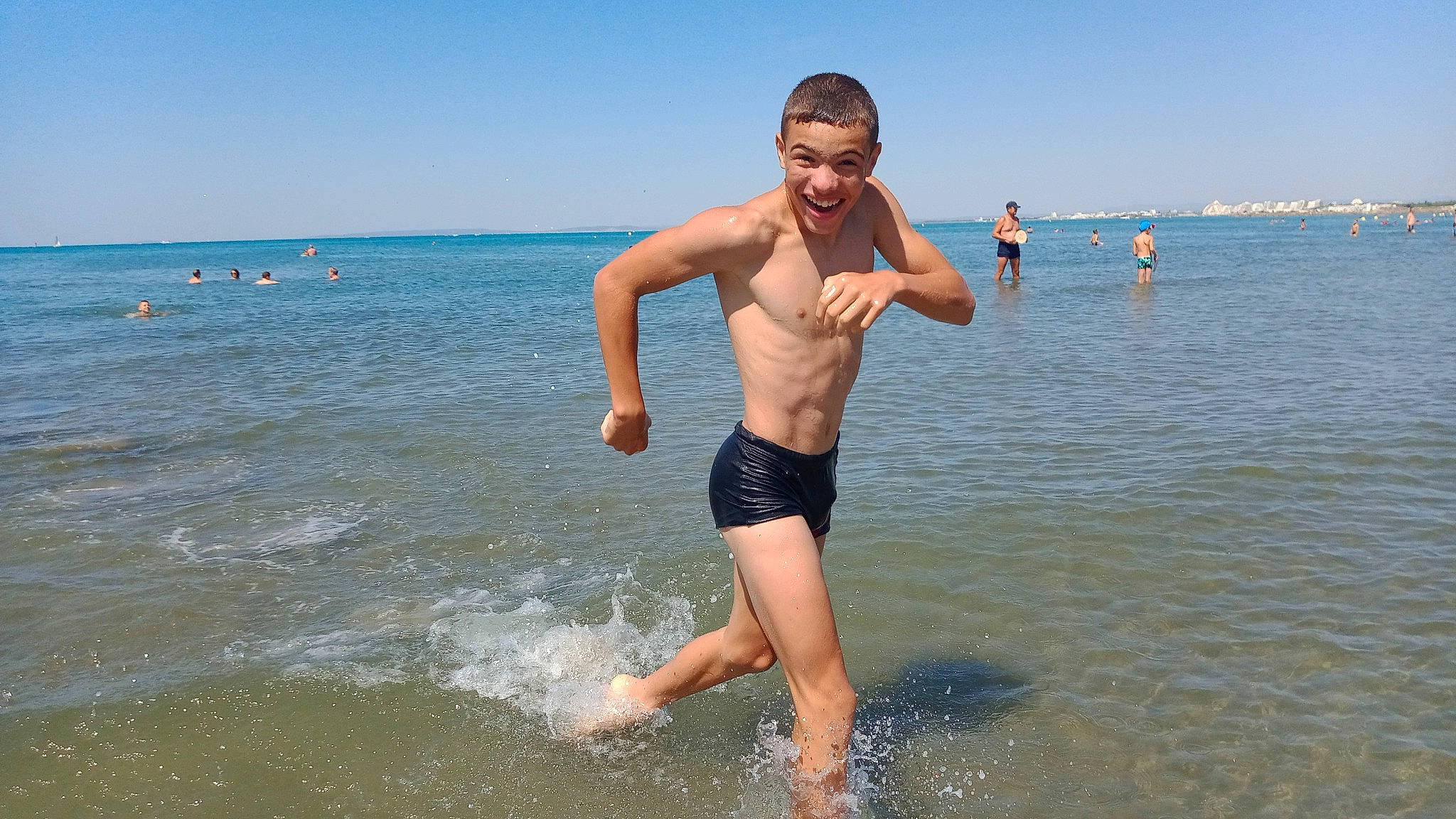Elizio participe au concours pour gagner de l'argent avec cette photo : barechested, barefoot, beach, chest, fun, happy, holiday, horizon, joy, lake, leisure, people_in_nature, people_on_beach, person, recreation, sky, smile, summer, swimwear, vertebrate
