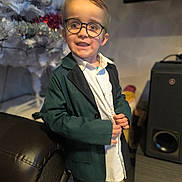 Maylone participe au concours pour gagner de l'argent avec cette photo : accessories, blazer, bodypart, boy, child, clothing, coat, couch, electronics, face, finger, formalwear, furniture, glasses, hand, jacket, male, person, speaker, suit