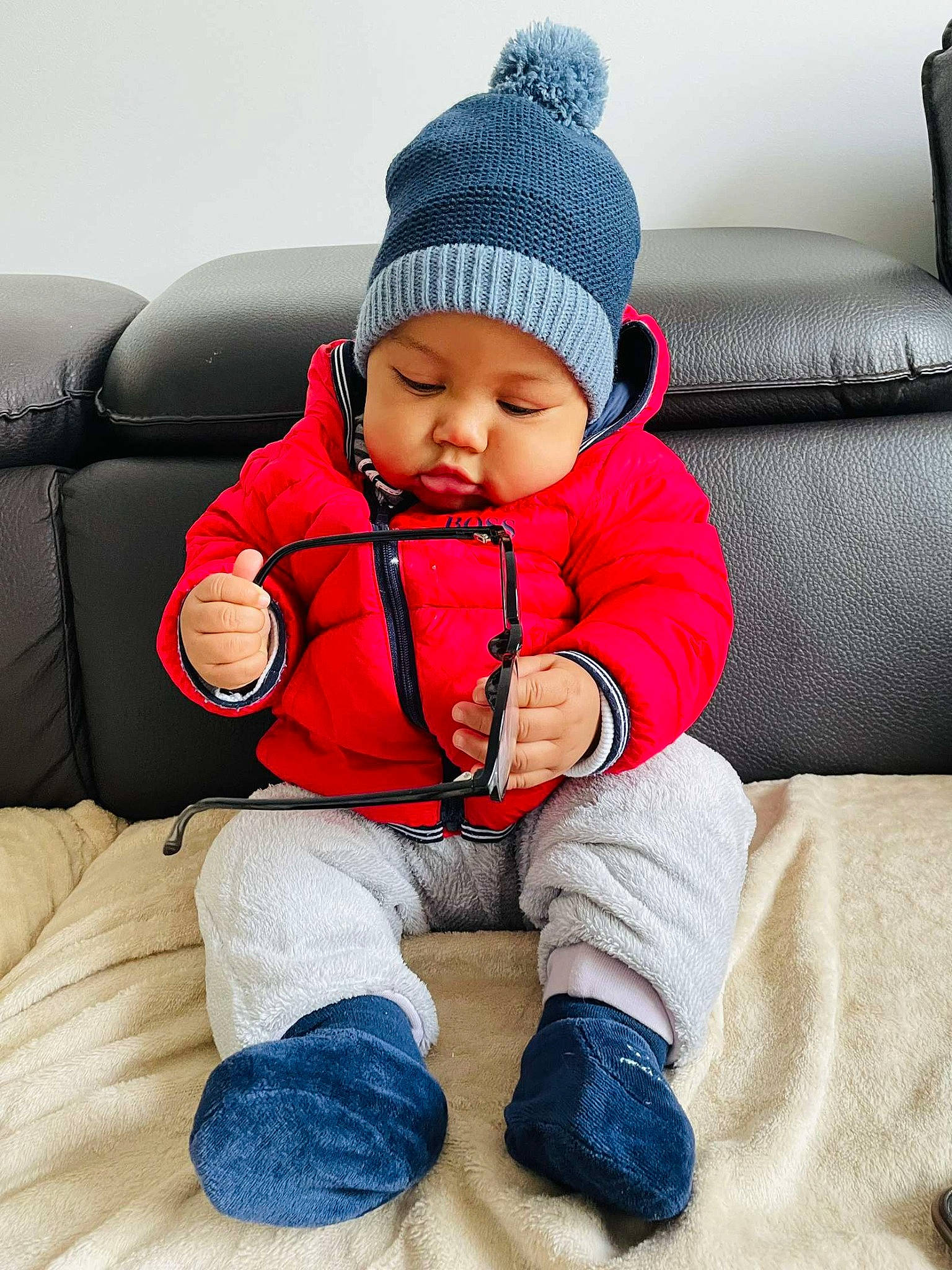 Evan participe au concours pour gagner de l'argent avec cette photo : baby, baby_sleeping, baby_toddler_clothing, beanie, cap, carmine, cheek, child, comfort, electric_blue, headgear, headwear, knit_cap, outerwear, person, sitting, sleeve, sock, toddler, travel