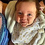 Scarlett joined the competition — help win amazing prizes! baby, infant, face, blue_eyes, blanket, bib, smile, indoor, clothing, person, cute, child, closeup, happy, soft_texture, wrapping, warm, skin, head, expression