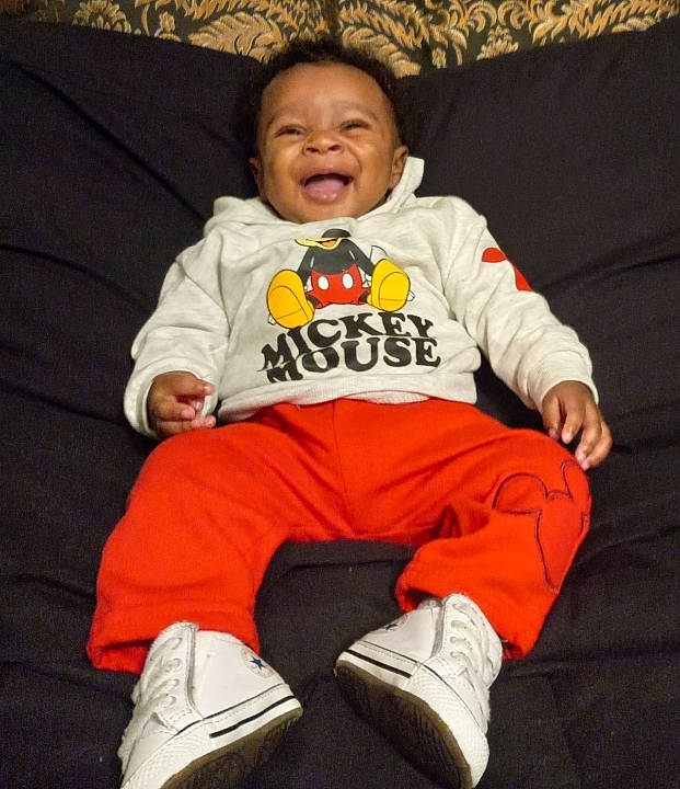 Amarye joined the competition — help win amazing prizes! baby, baby_toddler_clothing, child, comfort, flooring, footwear, fun, happy, jersey, orange, outerwear, person, shoe, sitting, sleeve, smile, sneakers, sportswear, t_shirt, toddler