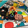 Sebastian joined the competition — help win amazing prizes! baby, infant, play_mat, toy, stuffed_animal, colorful, floor_cushion, child, smiling, indoor, play_area, cute, happy, black_clothing, patterned_clothing, soft_toys, toddler, baby_toy, baby_play, child_playing