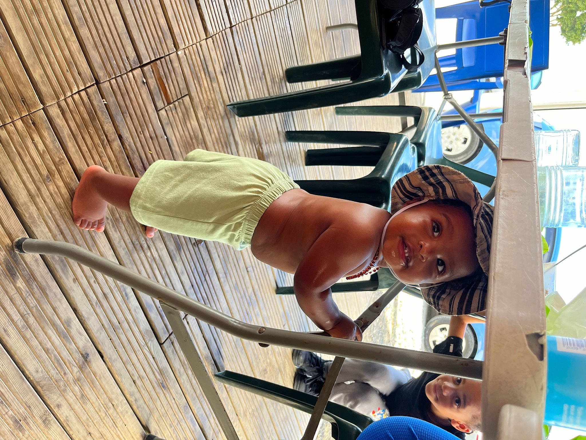 Kaylann participe au concours pour gagner de l'argent avec cette photo : barechested, chair, child, fun, hat, headwear, human_leg, leisure, outdoor_furniture, person, recreation, sandal, shorts, sitting, sun_hat, swimwear, t_shirt, thigh, toddler, tree