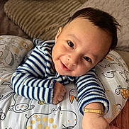 Liam joined the competition — help win amazing prizes! animal_print, baby, bright_eyes, child, couch, cozy, cushion, cute, face, happy, home, indoors, infant, person, pillow, portrait, resting, smiling, striped_clothing, young_child