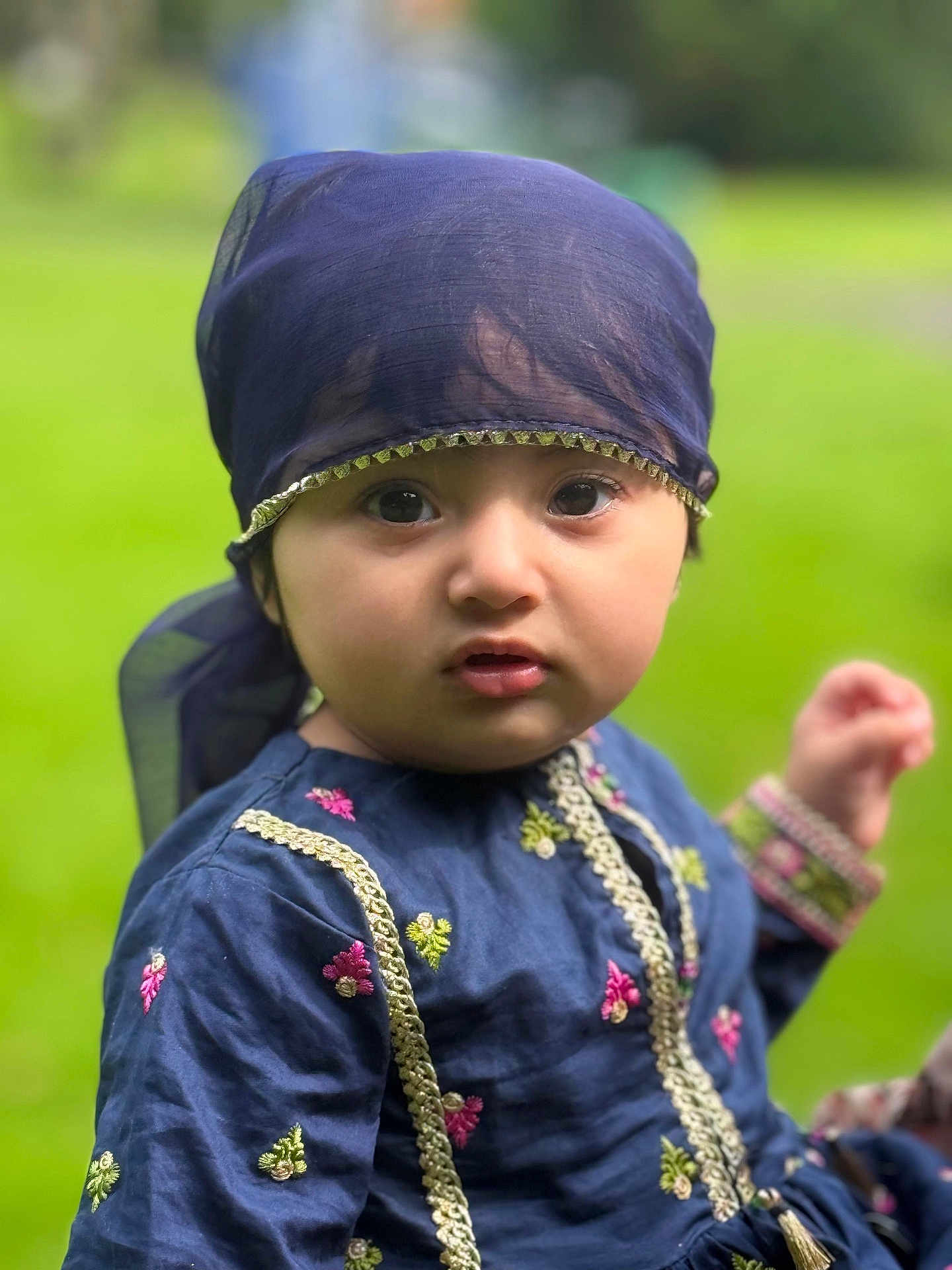 Haya joined the competition — help win amazing prizes! child, toddler, face, headscarf, blue_clothing, embroidery, outdoor, green_background, curious, portrait, person, young_child, cute, fashion, nature, closeup, eyes, expression, traditional_clothing, baby