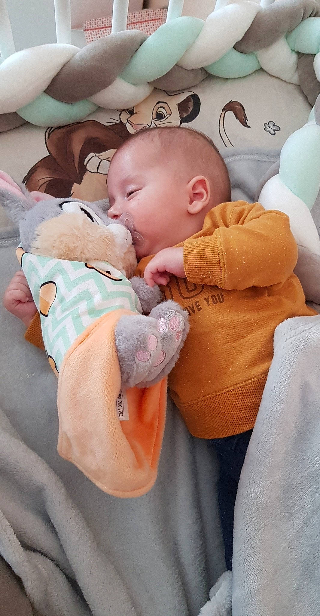 Stélios participe au concours pour gagner de l'argent avec cette photo : baby, baby_products, baby_sleeping, baby_toddler_clothing, bedtime, cheek, child, comfort, gesture, happy, head, linens, mouth, nap, orange, person, room, sitting, skin, sleeve