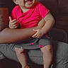 Rubi is registered to the contest to win money with this photo: baby, barefoot, cherry_pattern, child, couch, curly_hair, cute, family, happy, holding, indoor, infant, joyful, person, pink_bows, pink_shirt, seated, skirt, smiling, warm