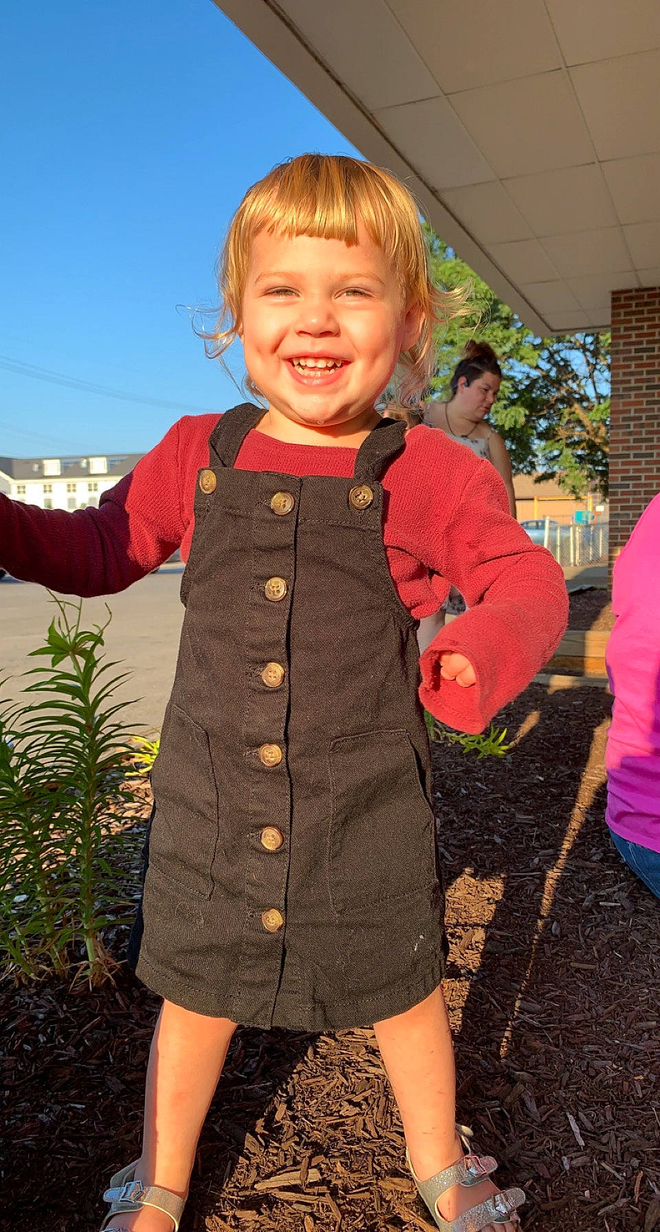Xavianna is registered to the contest to win money with this photo: baby_toddler_clothing, child, clothing, facial_expression, fun, gesture, grass, happy, joy, leg, orange, people_in_nature, person, plant, shoulder, sky, sleeve, smile, standing, thumb