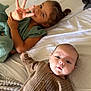 Zayyan a rejoint le concours — aidez-le/la à gagner de superbes lots ! child, baby, bed, blanket, brown_clothing, curly_hair, cute, expression, face, finger_gesture, girl, infant, knitwear, laying_down, light_skin, looking_at_camera, person, playful, smiling, soft_lighting