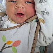 Liam participe au concours pour gagner de l'argent avec cette photo : baby, infant, close_up, white_hat, blanket, cozy, cute, newborn, face, expression, clothing, pattern, leaf, soft, warm, portrait, child, indoors, wrapped, sleepwear