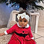 Assa a rejoint le concours — aidez-le/la à gagner de superbes lots ! baby, child, toddler, dress, headband, bow, christmas_tree, holiday, festive, cushion, floor, tile, indoor, curly_hair, cute, sitting, red_dress, white_trim, black_belt, decorations