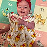 animal_print, baby, bracelet, child, clothing, colorful, cute, dress, happy, headband, indoors, infant, lying_down, play_mat, portrait, red_bow, smile, smiling, toddler, winnie_the_pooh