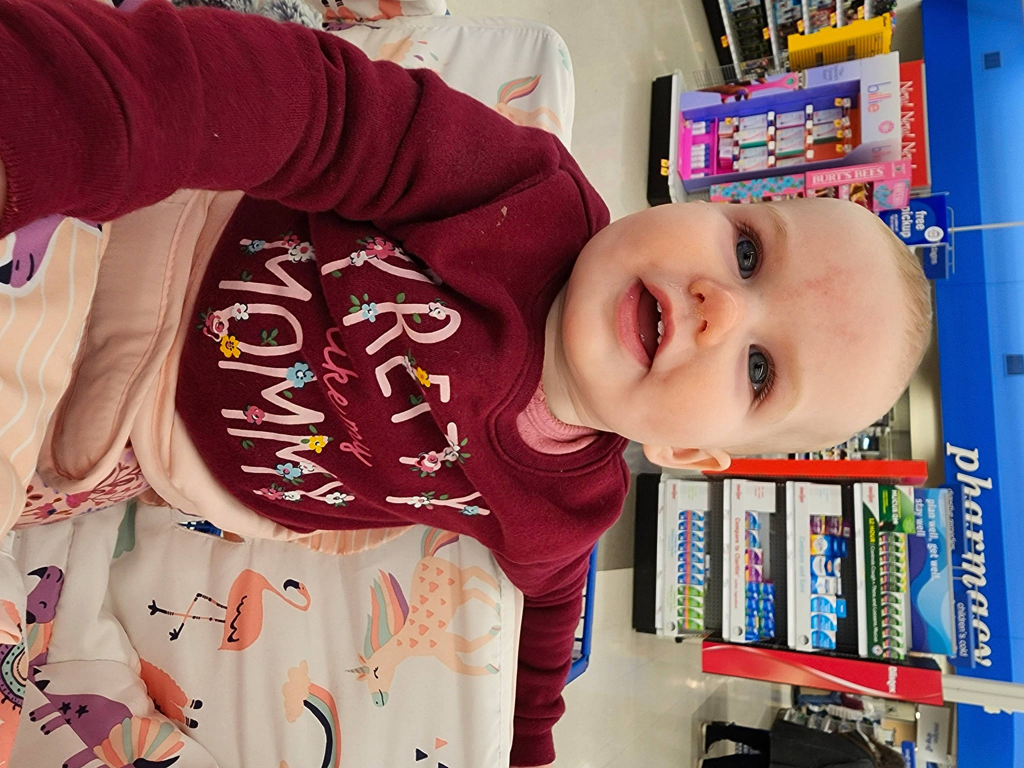 Lily is registered to the contest to win money with this photo: baby, baby_toddler_clothing, beauty, bookcase, child, happy, head, house, people, person, play, product, publication, retail, room, shelf, shelving, sleeve, smile, t_shirt