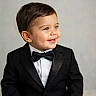 black_jacket, bow_tie, boy, buttoned_shirt, child, cute, face, formal_wear, hair, happy, indoor, light_background, person, portrait, smile, studio_shot, suit, toddler, tuxedo, young_child