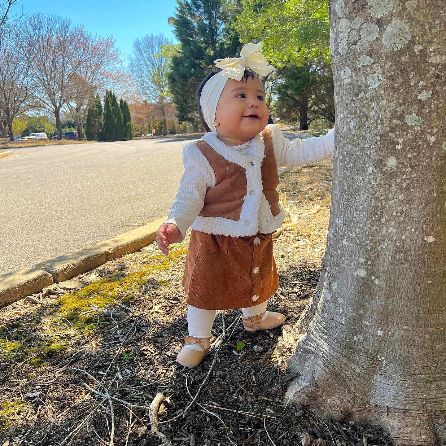 Hannely is registered to the contest to win money with this photo: baby, bonnet, car, clothing, dress, face, hat, head, land, outdoors, pants, person, photography, plant, portrait, sitting, transportation, tree, vegetation, vehicle