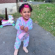 Aimee is registered to the contest to win money with this photo: child, toddler, smiling, happy, outdoors, portrait, curly_hair, headband, pink_clothing, pajamas, boots, purse, toy, unicorn_toy, brick_house, yard, grass, driveway, autumn_leaves, standing