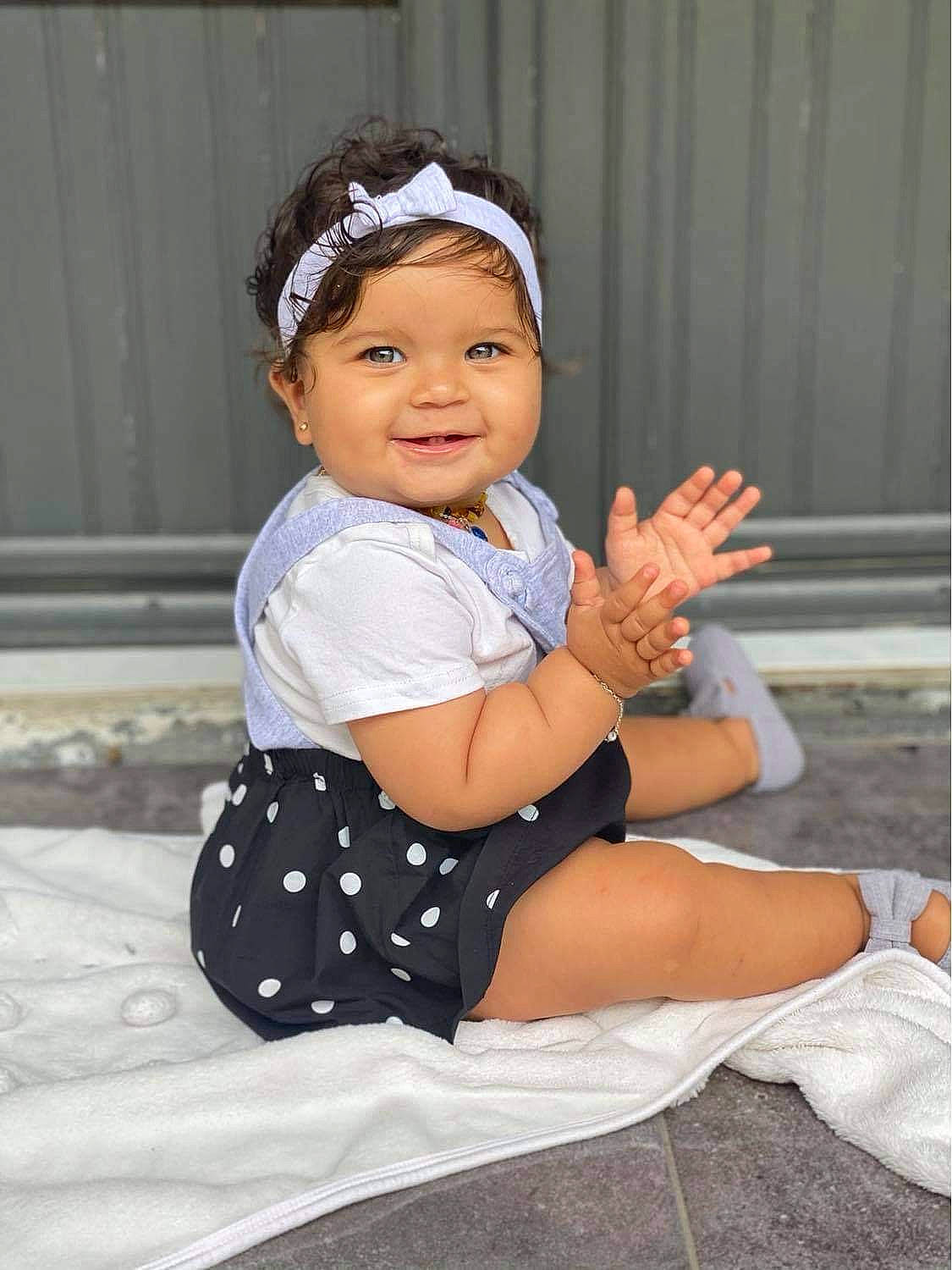 Chelsea participe au concours pour gagner de l'argent avec cette photo : baby, baby_toddler_clothing, black_hair, cap, child, dress, eye, finger, flash_photography, foot, happy, hat, headwear, human_body, human_leg, joy, knee, person, sleeve, smile
