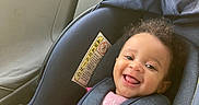 Nazarielle is registered to the contest to win money with this photo: baby, child, car_seat, smiling, happy, curly_hair, safety_harness, pink_clothing, seatbelt, vehicle_interior, window, child_safety, infant, cute, portrait, seat, car, person, young_child, secured