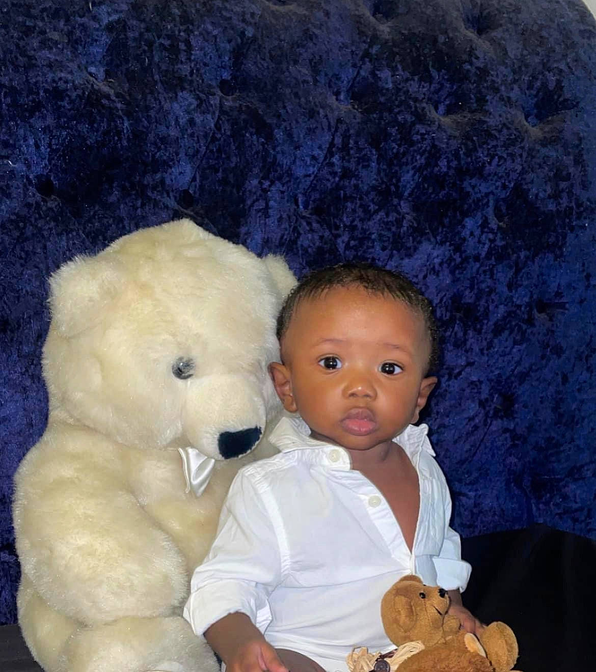 Marcel is registered to the contest to win money with this photo: afro, baby, baby_toddler_clothing, baby_toys, cheek, child, comfort, eye, fun, fur, happy, head, nose, organ, person, plush, room, stuffed_toy, teddy_bear, toddler