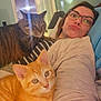 woman, glasses, cat, kitten, tabby_cat, indoor, bed, couch, striped_clothing, pet, relaxing, cozy, feline, animal, person, eyewear, face, resting, domestic, comfort