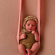 Gina a rejoint le concours — aidez-le/la à gagner de superbes lots ! baby, infant, newborn, child, knitted_sling, bonnet, brown_outfit, pink, beige_background, portrait, cute, small, wrapped, hands, feet, soft_texture, studio, posing, resting, young