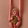baby, infant, newborn, child, knitted_sling, bonnet, brown_outfit, pink, beige_background, portrait, cute, small, wrapped, hands, feet, soft_texture, studio, posing, resting, young