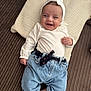 Gina participe au concours pour gagner de l'argent avec cette photo : baby, infant, smiling, headband, bow, white_clothing, denim_pants, rolled_up_pants, pillow, textured_pillow, striped_surface, cute, happy, lying_down, indoor, child, person, casual_clothing, small_hands, bare_feet