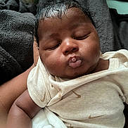 Ashtyn is registered to the contest to win money with this photo: baby, infant, sleeping, puckered_lips, clothing, white_outfit, arm, hand, skin, face, peaceful, close_up, newborn, soft_texture, blanket, resting, cute, child, portrait, indoors