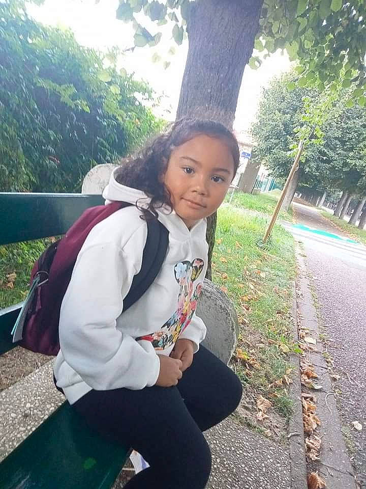Ezia participe au concours pour gagner de l'argent avec cette photo : asphalt, black_hair, child, fun, grass, happy, leggings, leisure, long_hair, person, plant, recreation, road, sitting, sportswear, t_shirt, thigh, tourism, tree, uniform